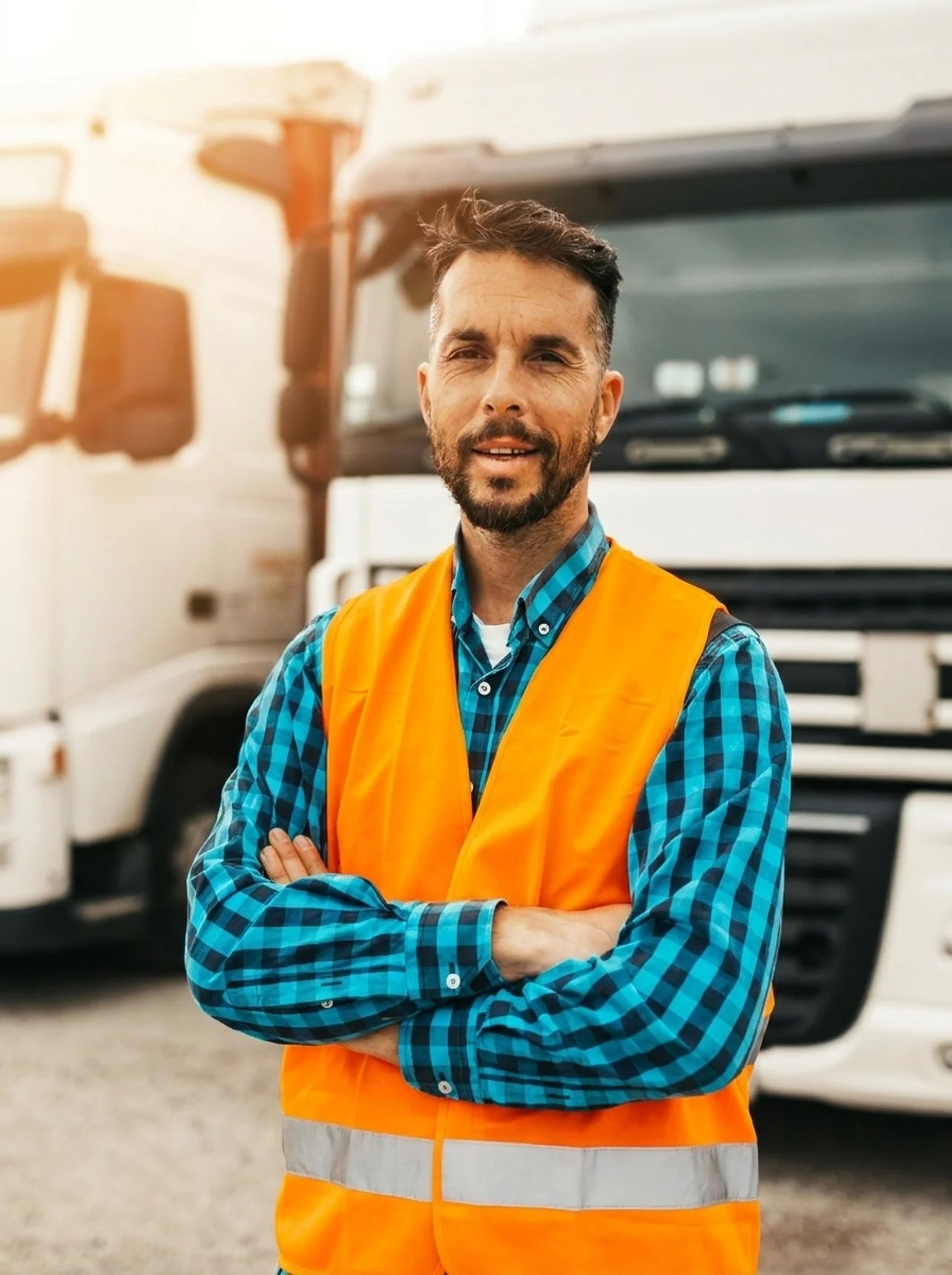 Truck driver in a high-visibility vest standing in front of his truck